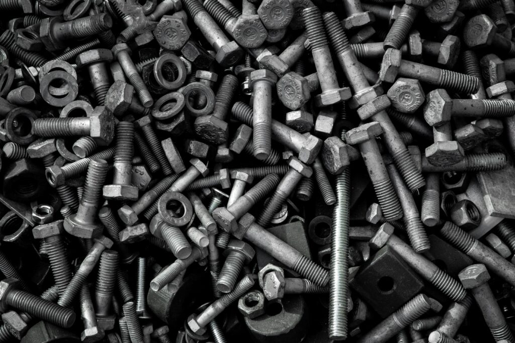 Detailed image of assorted industrial bolts and screws for recycling or mechanics.
